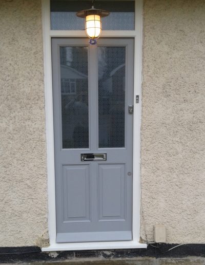 grey timber door with silver letterbox